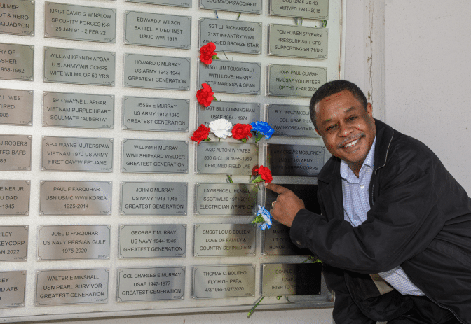 A man pointing to a wall data plate.