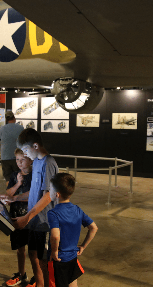Three kids looking at a screen inside the museum.