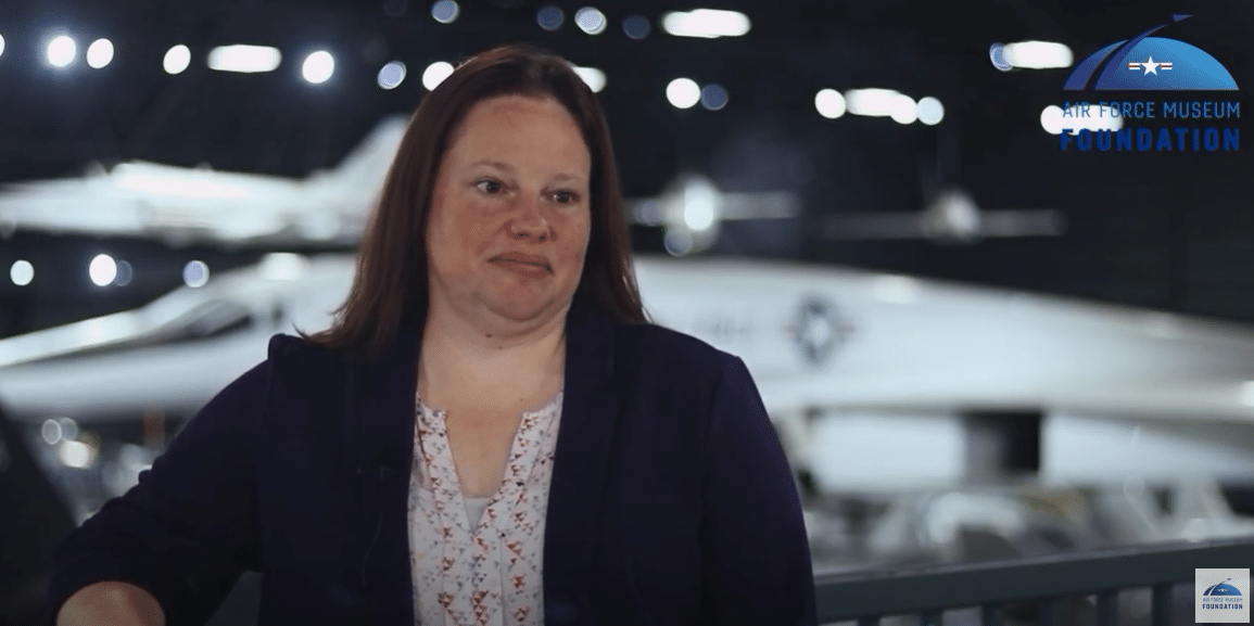 Video still of a woman in air force museum.